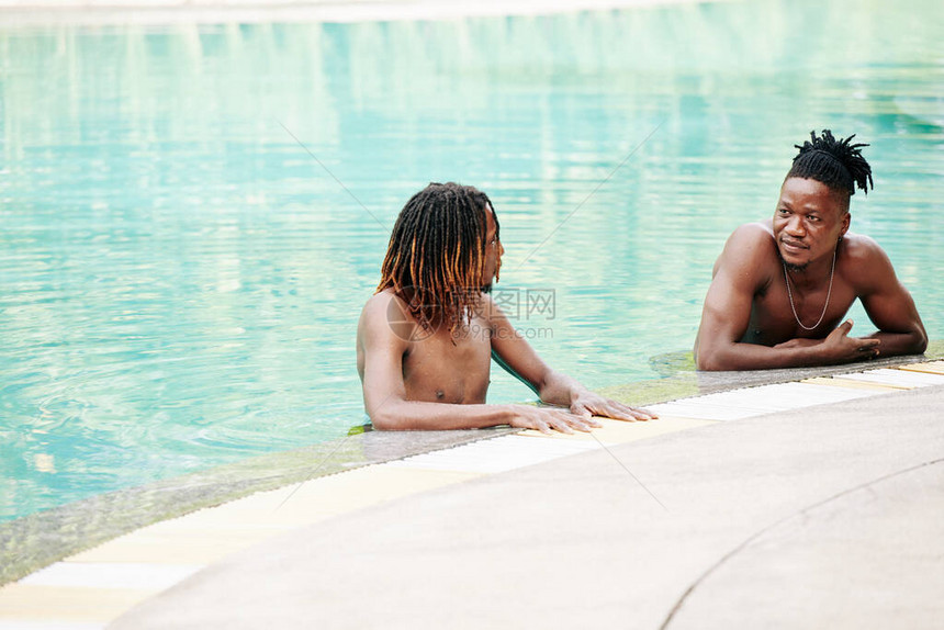 黑人青年男子站在游泳池里在游泳图片