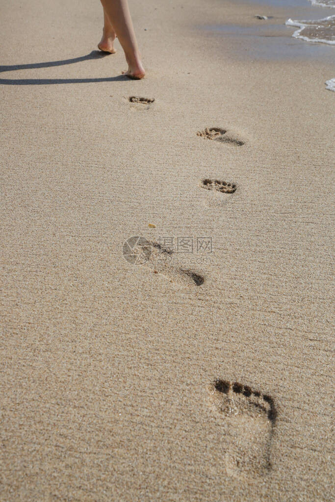 赤脚在沙滩上行走的图片