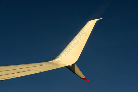 一架飞机在巡航高度对深蓝天空的弯翼顶端的背景图片