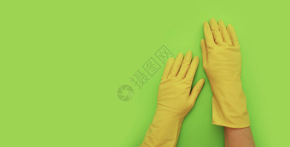 女用黄色手套在彩色背景上打扫时图片