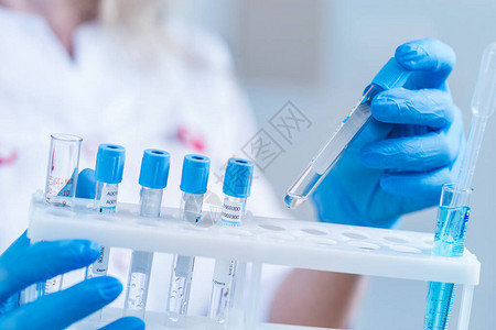 科学家或医生在实验室外套与试剂管含有化学液体的实背景图片