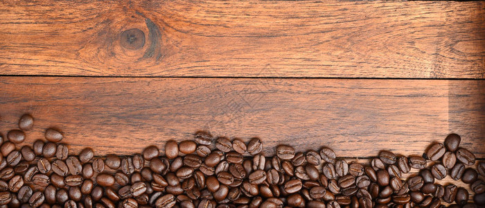 木制背景上的咖啡豆特写图片