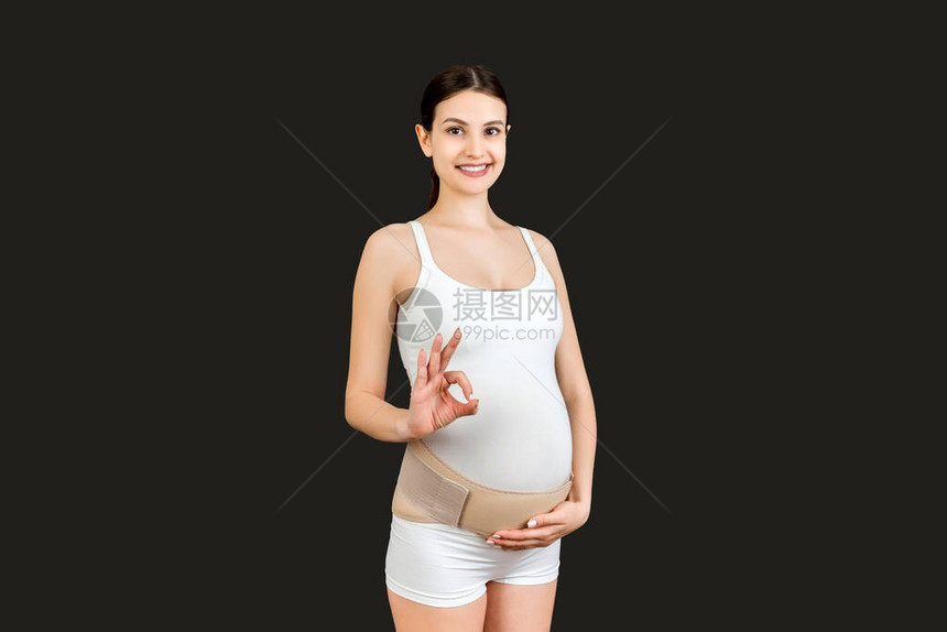 孕妇的肖像在她的腹部上贴着妊娠绷带图片