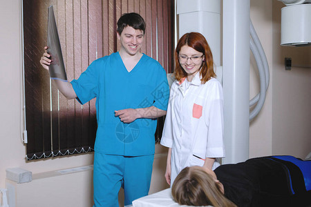 妇女和男子放射科医生在医务室检查病人附近图片