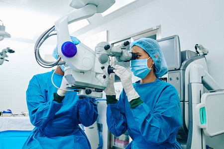 亚洲女外科医生在手术病人时使用电子显图片