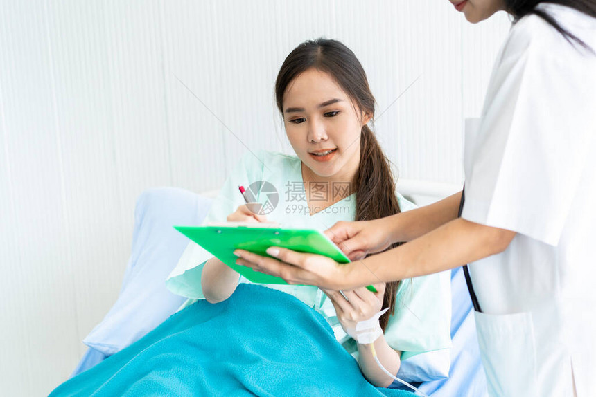 医生将医疗支出信息和合同带到医院病房的患者并要求她签名图片