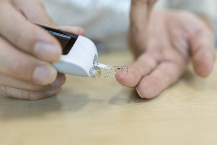用手指上的葡萄糖计检查血糖水平的人手的特写用作医学糖尿病血糖保图片