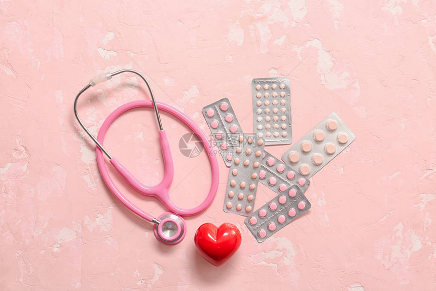 彩色背景上的听诊器心脏和药丸心脏病学概念图片