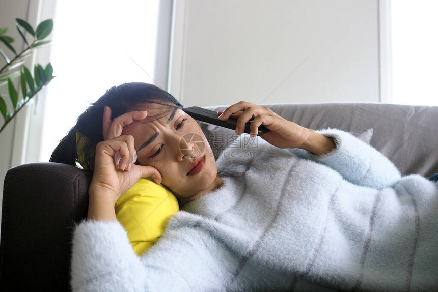 躺在沙发上的生病女人在接到电话中的坏消息后图片