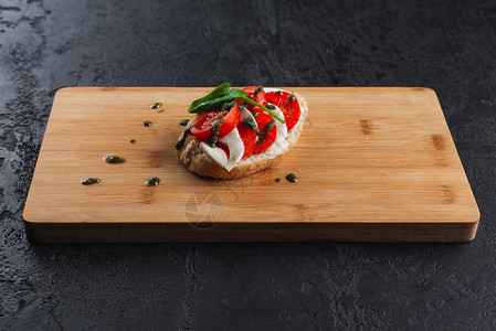 木板上有西红柿和马苏里拉奶酪的意式烤面包图片