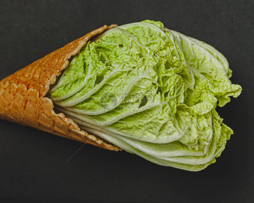 健康饮食的概念以冰淇淋和沙拉叶的形式出现在黑底背景图片