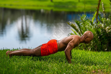 健身模特在草地上摆板的照片使用离机闪光灯和自然图片
