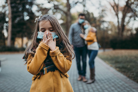 公园户外保护面罩的年轻家庭空气污染概念图片
