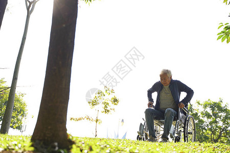 试图从户外轮椅上站起来的亚洲老人图片