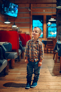 可爱的白种人蹒跚学步的男孩站在咖啡馆餐厅看电视频道节目三岁的孩子对电子数背景图片