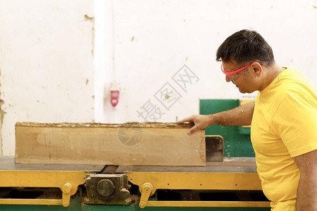 木匠在其木工车间用圆锯砍柴作为家具图片
