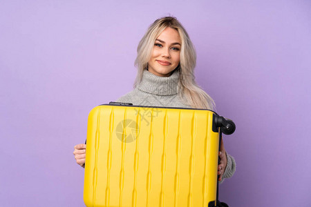 在假期中带着旅行李箱渡过孤立的紫色背图片