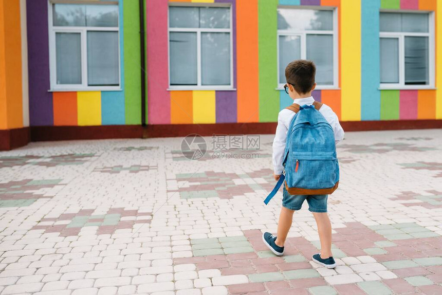 小男孩要回学校了第一个上学日背着书包和书本的孩子后视图学校理图片