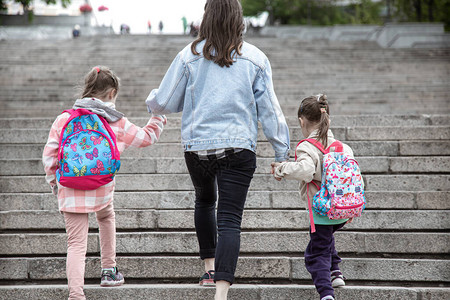 小学的家长和学生齐头并进两个女孩的妈背着一个背包上课的开始图片