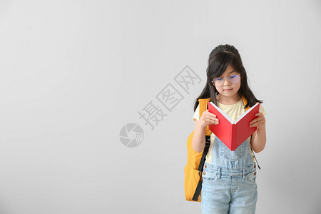 浅色背景下的小女生看书的肖像图片