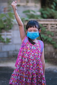 身着面罩的亚洲女学生准备上学了图片