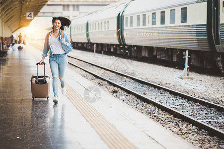 亚洲女游客在火车站提着行李跑积极和旅行图片