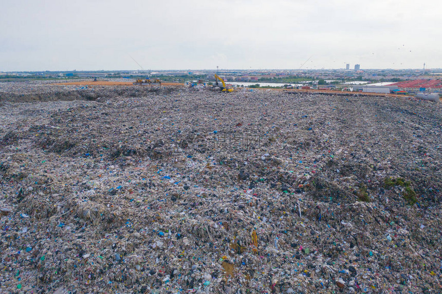 环境污染工业厂房中不同类型的大型山地垃圾堆塑料袋和垃圾与拖拉机车的鸟瞰图倾倒图片