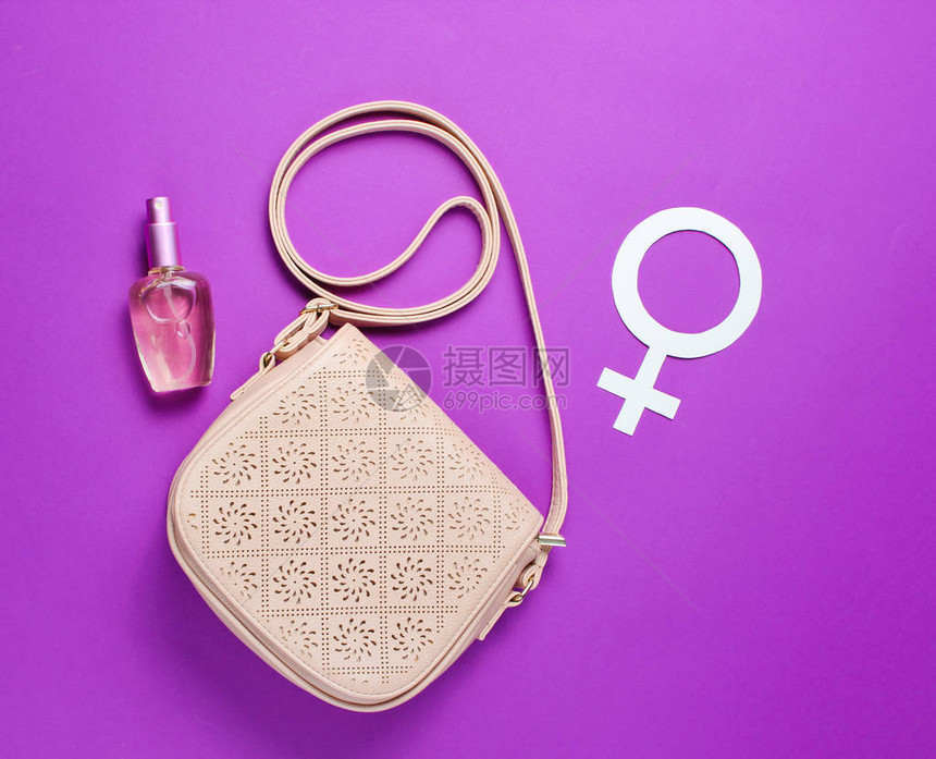 女时装袋香水瓶紫色背景上的别女权主义符图片