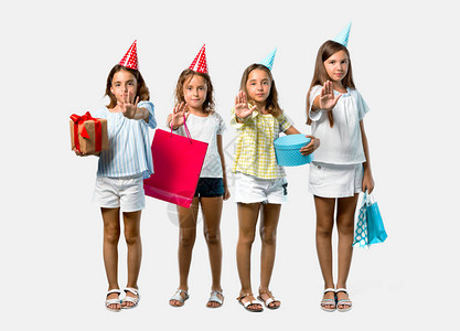 一群小女孩在生日派对上拿着礼物袋用灰色背景的手做停止手图片