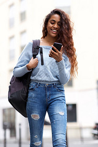 快乐的女孩在街头开心的玩手机图片