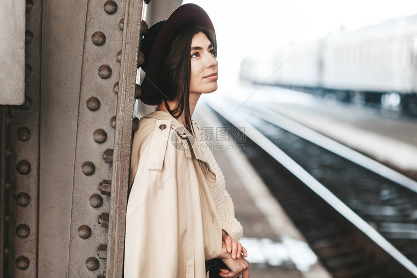 火车站台上等火车的年轻美女旅客肖像图片
