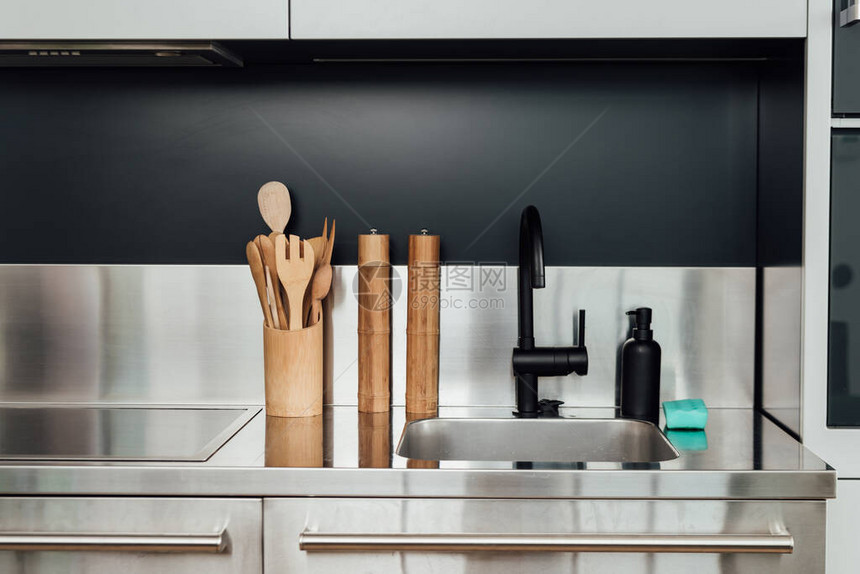 厨房中靠近水龙头水槽肥皂撒布机和海绵的木制胡图片