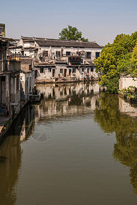 在浅蓝天空下的运河褐色水中图片