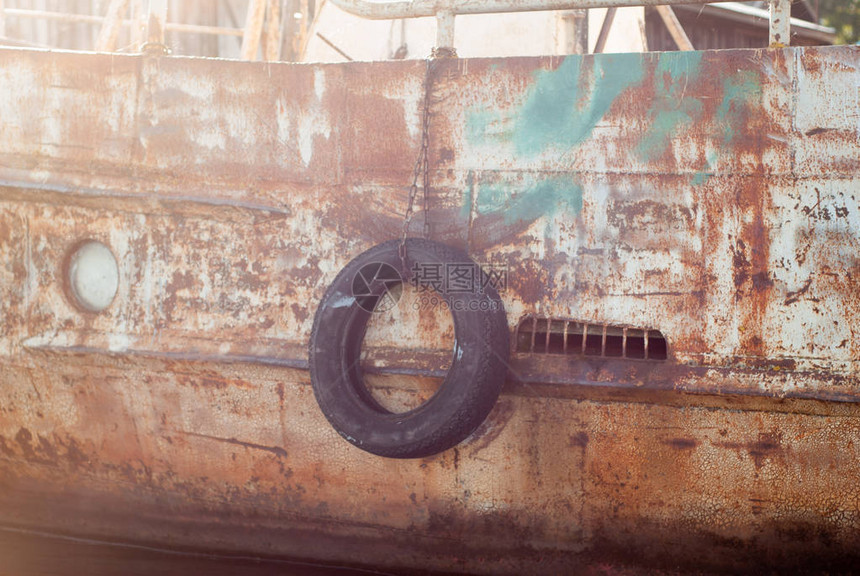 码头旧船上的黑色轮胎特写图片