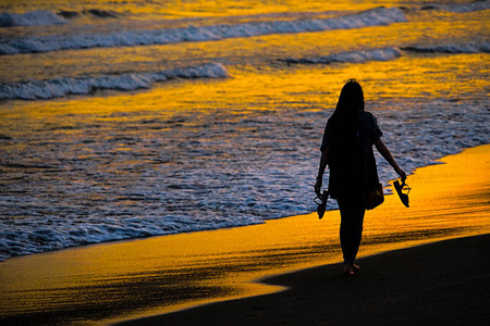 黄昏的海滩和妇女剪影图片