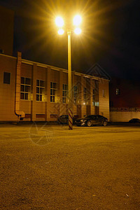 用车照亮一个夜间停车场和停放汽图片