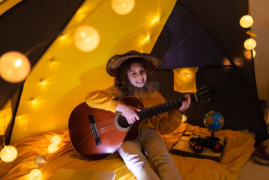 小女孩在的帐篷下弹吉他图片