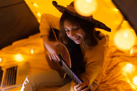小女孩在客厅的帐篷下弹吉他图片