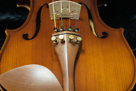 深色背景中木制小提琴的特写背景图片