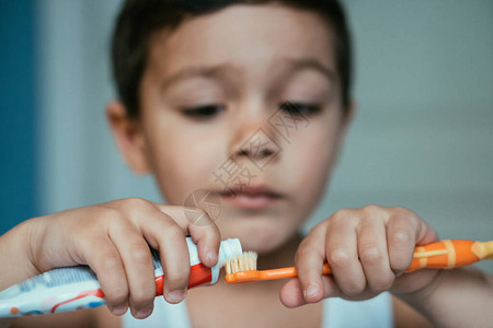 在牙刷上涂牙膏的勤快的男孩有图片
