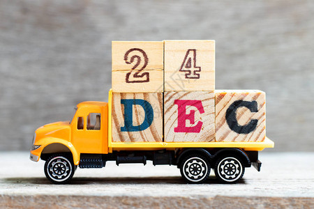 卡车在木材背景上持有24Dec字的母块日期为1图片