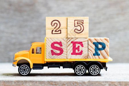 卡车在木材背景上持有字数为25sep的字母块设想日期为2图片