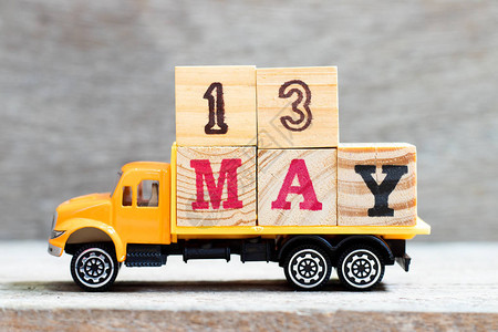卡车在木材背景上持有字号为13的字母块设想日期为图片
