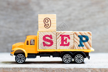 卡车在木材背景上持有9秒字的母块日期为图片