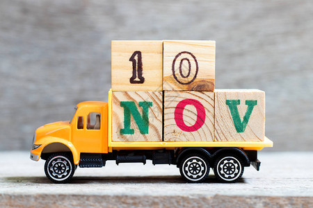 卡车在木材背景上持有10nov字的母块设想日期为1图片