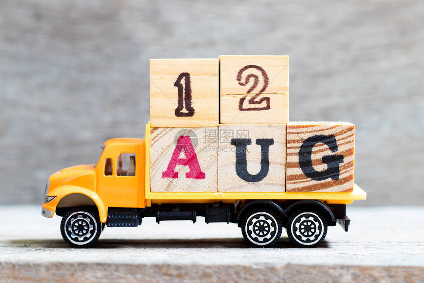 卡车在木材背景上持有12aug字的母块规定日期为图片
