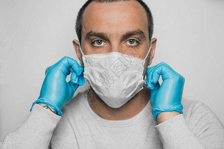 一个男人把医用口罩戴在脸上图片