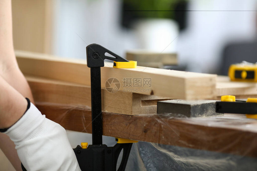 木工将木制零件固定在工作台上虎钳安装在工作台上使用特殊的木工具仔细加工和整理木制品调整形图片