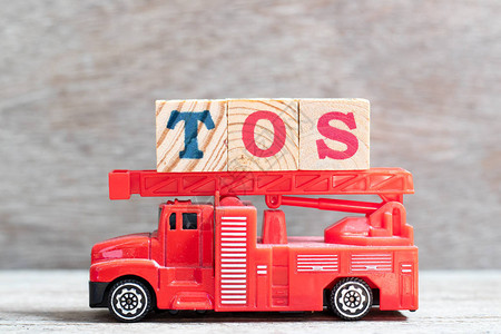 红色消防车在木材背景上用TOS字封住字母块服务条款图片