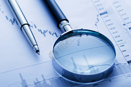 商业图表上的放大镜和笔在会计研究或审计的概念中显示波动的业绩图片